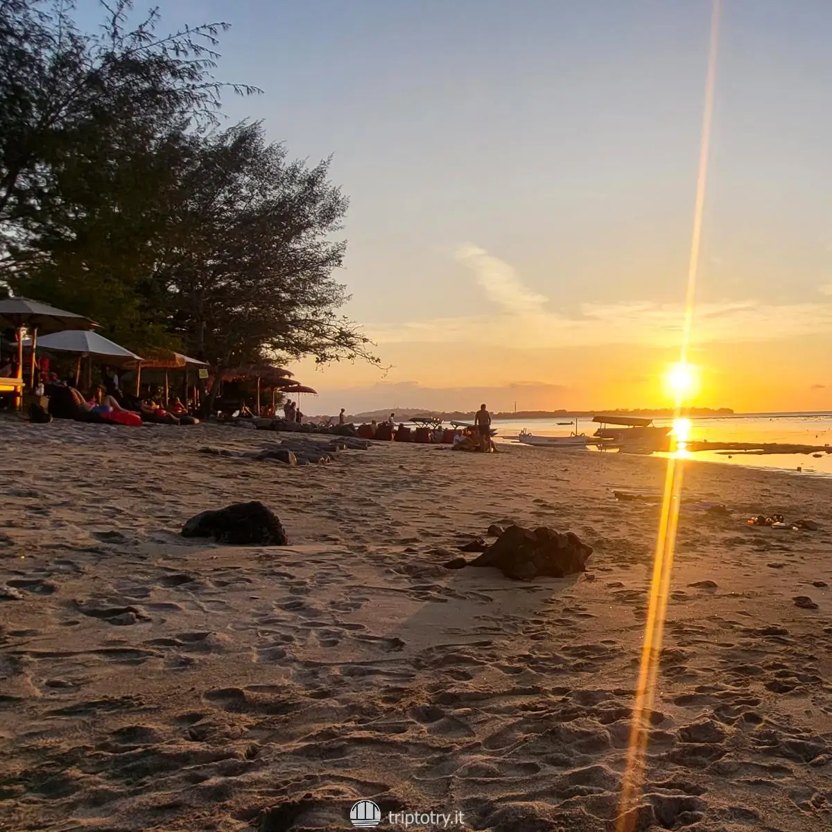Isole Gili quale scegliere? Aperitivo al tramonto sulla spiaggia con sole sul mare alle isole Gili in Indonesia - the best gili island to visit