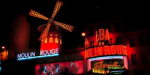 10 cose da vedere parigi - Moulin Rouge illuminato da luci rossi di notte a Parigi