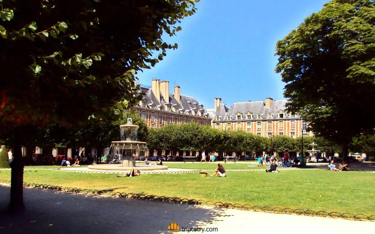 10 cose da vedere parigi - Il giardino soleggiato e gli edifici rossi della Place des Vosges a Parigi
