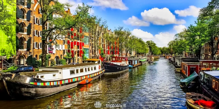Itinerario per visitare Amsterdam in 3 giorni - Canale d'acqua nel centro di Amsterdam, con case colorate, alberi verdi e barchette - 3 day itinerary amsterdam